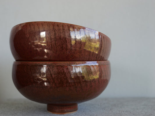 Set of two red iron footed bowls